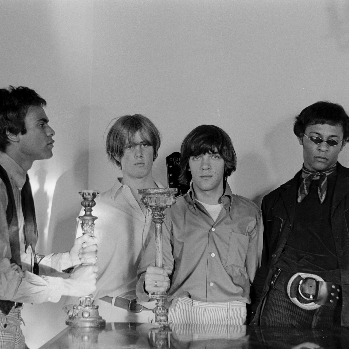 The band Love posing with candlesticks, photographed by Ronnie Haran